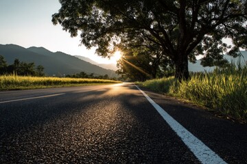 Obraz premium Asphalt Road Leading Through Scenic Countryside at Sunset