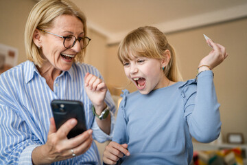 Fototapeta premium grandma and granddaughter have online shopping in the living room