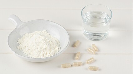 High quality collagen powder with supplements and water on wooden backdrop Ideal for beauty health and wellness concepts