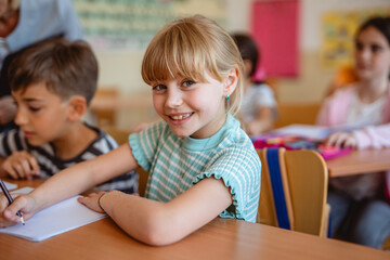 pretty school girl pupil sit in school class in the classroom