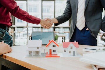 Real Estate Deal Handshake with House Models