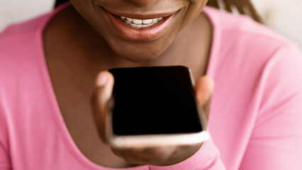 Voice Search Concept. Closeup portrait of black woman using personal assistant app on smartphone at...