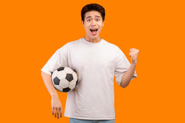 Go On. Portrait of excited young asian man making winner gesture, watching football game, standing...