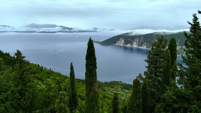 Aerial drone view of Ithaca Mountain region foggy clouds summit villages church monastery Panagia Eleousia high up bays of blue water lush green water area Scenic veiws