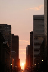 breathtaking sunset behind towering skyscrapers casting long shadows on city streets