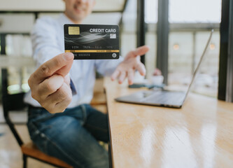 Man Holding Credit Card at Desk