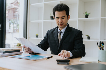 Asian Businessman Analyzing Financial Documents