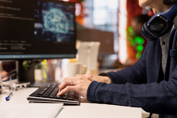 Engineer typing on computer keyboard in startup office designing, coding and debugging applications...