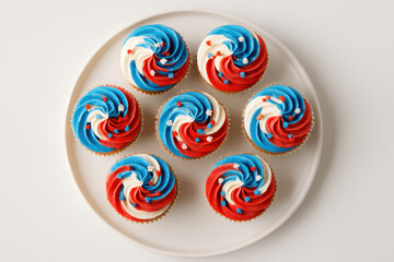 Colorful cupcakes with red, white, and blue frosting on plate  