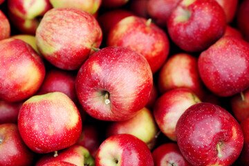 Apple texture, natural background, healthy food, diet, vitamins, organic fruit and great harvest. A lot of delicious fresh red apples in farm, warehouse or store, outdoor, copy space, close up