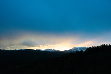 sun dipping behind the Colorado Rocky Mountains 