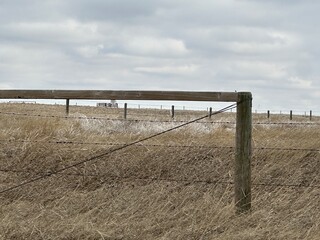 farm fencing used to enclose open fields and livestock pasture in rural Alberta, Canada.