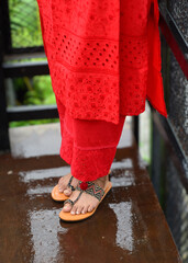 A lady wearing sandals that has flowers on it