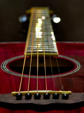 Close-Up of Acoustic Guitar with Strings: Moody Lighting on Instrument	