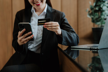 Woman Using Phone and Credit Card for Online Payment