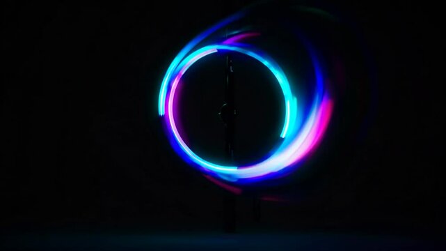 Colorful led poi spinning in darkness, creating mesmerizing light circles through multiple exposure technique, revealing vibrant energy and dynamic visual performance
