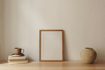 Minimal Mediterranean interior still life. Cup of coffee, books. Empty wooden picture frame mockup...