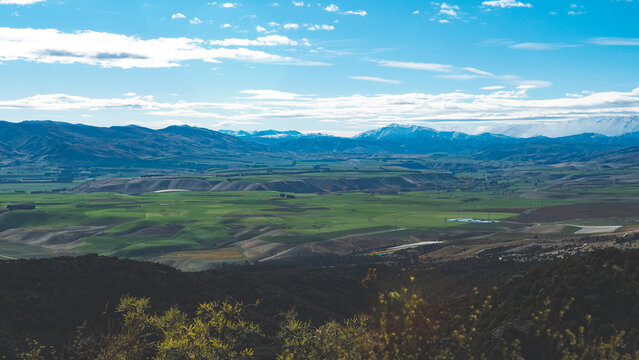 Kanuka loop track in bendigo central otago new zealand stunning views valley mountain peaks covered in snow green hills, blue sky postcard scenery