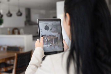 Woman pointing camera toward dining area using tablet, taking photo of interior, filming property for virtual tour, conduct remote viewing for client, create content for home design, renovation blog