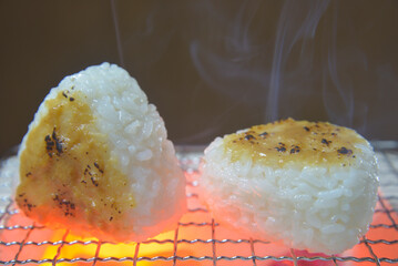 煙り立ち昇る七輪で味噌おにぎりを焼く