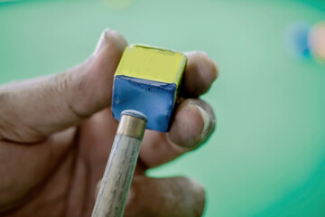 Close up of snooker is chalking cue. Concept of playing activity,