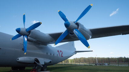 Naklejka premium A vintage Soviet aircraft features striking blue propellers, positioned near a forest in Russia, capturing the essence of Cold War aviation and history.