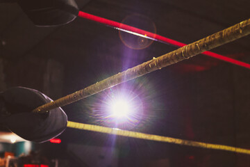Ropes of a wrestling ring highlighted by spotlight © Robin