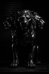 a metallic statue of a lion with 3 faces, on a white background