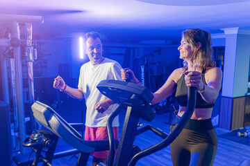 Couple working out in home gym, Personal trainer assisting client
