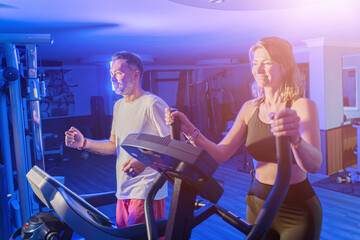 Couple working out in home gym, Personal trainer assisting client
