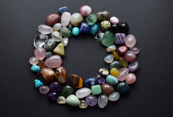 Natural stones of different colors are laid out in a circle. Predictions, witchcraft, spiritual esoteric practice. Background of precious stones.