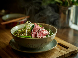 Pho: Vietnamese pho with aromatic beef broth, rice noodles, and herbs. Topped with rare steak&mdash;steamy bowl for Asian cuisine blogs or cozy winter meals.