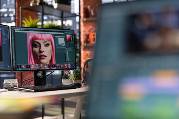 Modern office workspace equipped for digital design and photo editing. Screens show advanced editing software for photographers and designers working on image retouching, contrast adjustments.