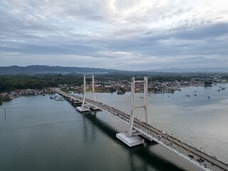 Fototapeta premium Aerial view of Kendari Bay Bridge, a suspension bridge connecting both sides of Kendari Bay in Southeast Sulawesi, Indonesia