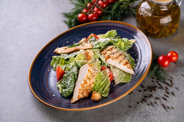 Freshly grilled chicken slices lay atop a bed of crisp romaine lettuce and ripe cherry tomatoes, garnished with cheese and a drizzle of olive oil, capturing a warm culinary moment