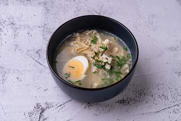 Warm and inviting, this chicken noodle soup features tender noodles and succulent chicken, topped with vibrant herbs and a beautifully sliced boiled egg, ready to be savored