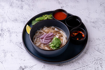 Delicately crafted dish featuring soft noodles adorned with fresh herbs, zesty lime, and vibrant chili, inviting culinary exploration and savoring rich flavors