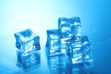Cubes of clear ice on light blue background, closeup