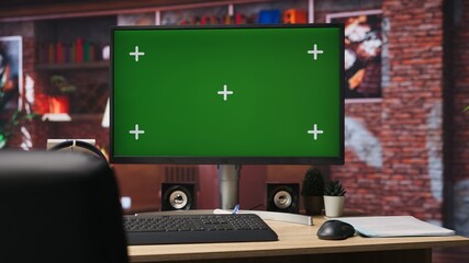Isolated screen mockup PC on home office desk with stationary items and headphones on, surrounded by plants. Chroma key computer display in loft with shelves filled with books in background