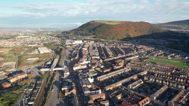 Sunny morning in town. Aerial footage of rows of houses along streets in urban neighbourhood. Port Talbot, Wales, UK