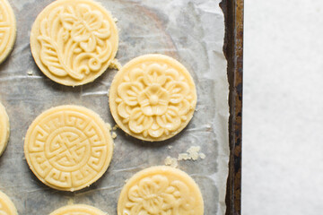 top view of stamped sugar cookie dough being cut out, Overhead view of cut out vanilla cookie dough, process of making vanilla sugar cookies