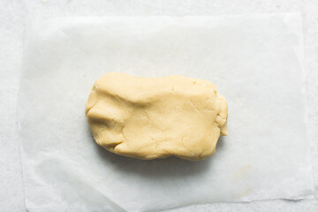 overhead view of vanilla sugar cookie dough being kneaded on countertop, top view of plain vanilla cookie dough being mixed, process of making sugar cookies