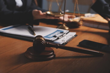 Attractive young lawyer in office Business woman and lawyers discussing contract papers with brass scale on wooden desk in office. Law, legal services, advice, Justice and real estate concept.