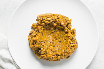 Overhead view of nigerian fried beans on a white plate, top view of nigerian stewed beans on a white background