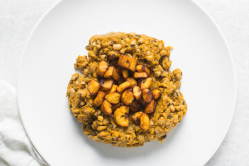 Overhead view of nigerian fried beans and fried plantain on a white plate, top view of nigerian stewed beans and plantain on a white background