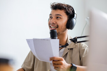 Asian Young Host Having Fun Talking on Microphone Inside Studio While Streaming Online Podcast