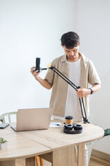 Asian Man Preparing to Record Podcast by Setting Microphone at Home Studio