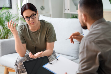 Obraz premium Female soldier with PTSD talking to psychologist in office