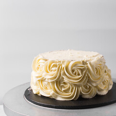 Piping rosettes on a cake using buttercream, Cake being covered in buttercream rosettes, cake being covered in american buttercream, process of decorating a cake