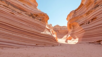 Striking sandstone formations in a desert canyon, revealing layers of colorful sedimentary rock under a clear sky